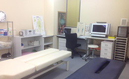 デスクおよび電動ベッド二台導入の治療室内